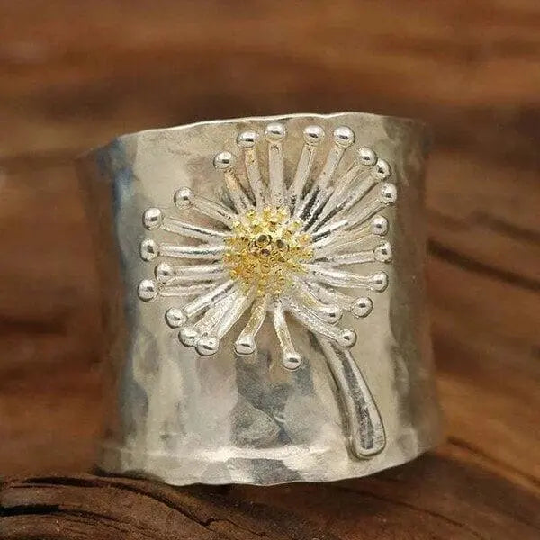 A ring in the shape of a blooming daisy with a wide band