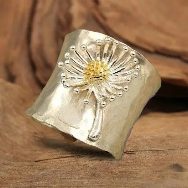 A ring in the shape of a blooming daisy with a wide band