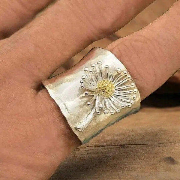 A ring in the shape of a blooming daisy with a wide band