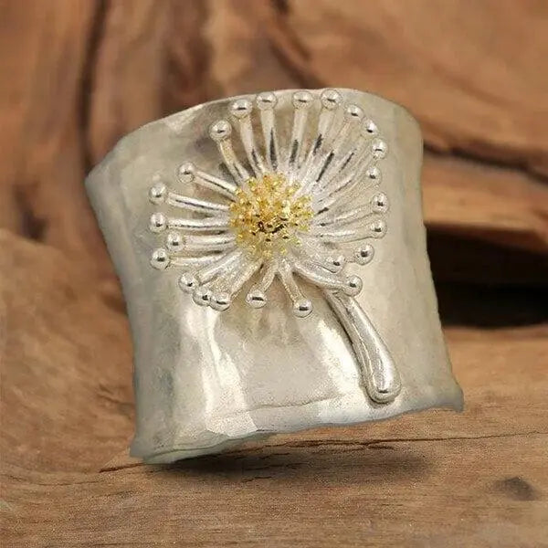 A ring in the shape of a blooming daisy with a wide band