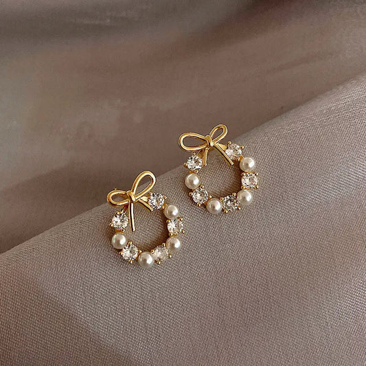Elegant hoop earrings with bow and pearl details